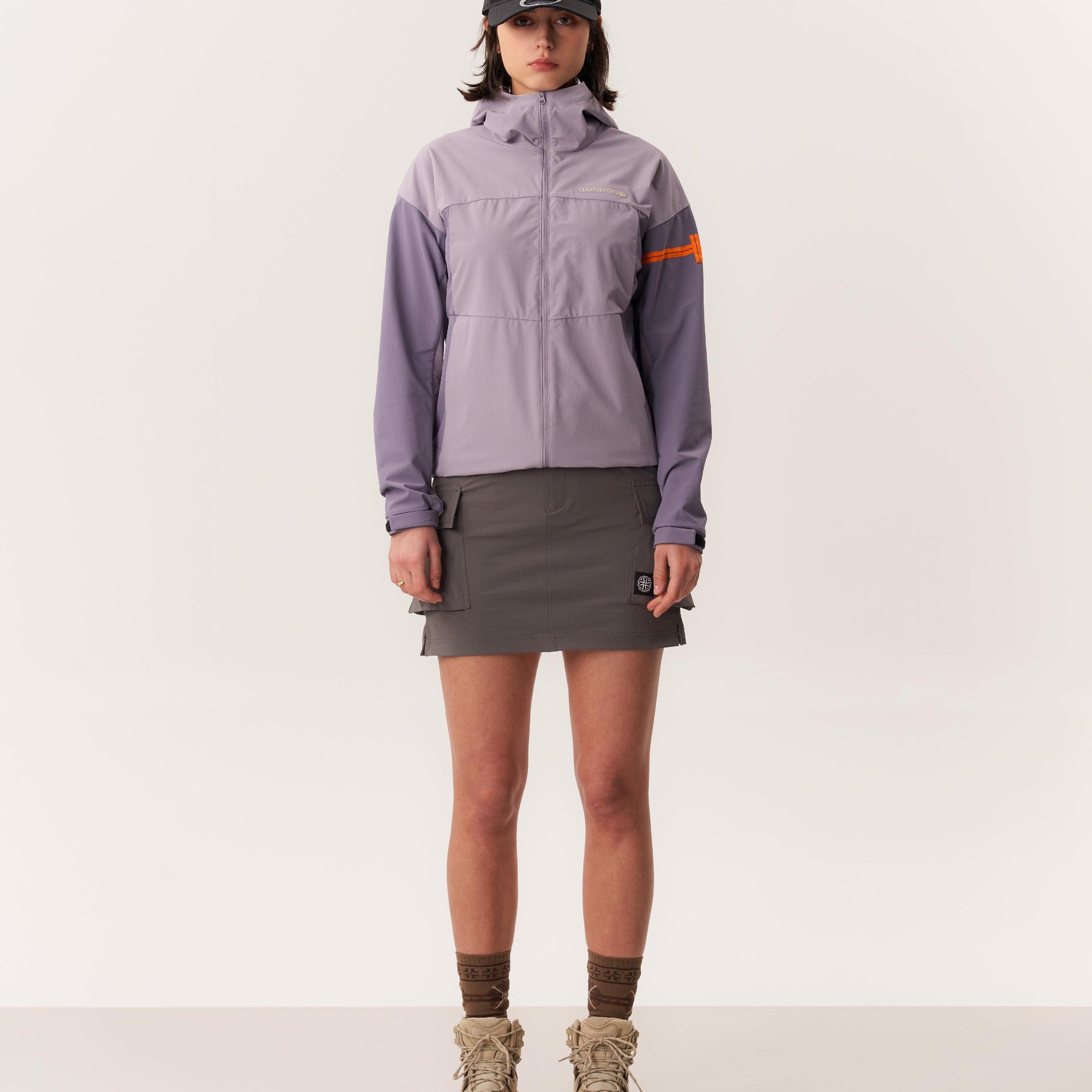Studio shot of model wearing Purple RENALA hiking jacket and KELTIE hiking skirt against white background
