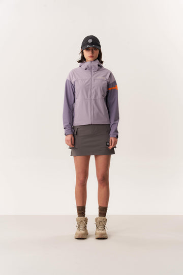 Studio shot of model wearing Purple RENALA hiking jacket and KELTIE hiking skirt against white background