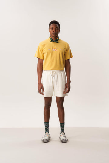 Model wearing sweat shorts and knit mule shoes against a neutral studio backdrop