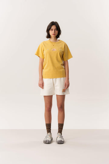 Model wearing soft cotton terry cloth T-shirt and knit mule shoes in a studio-lit environment
