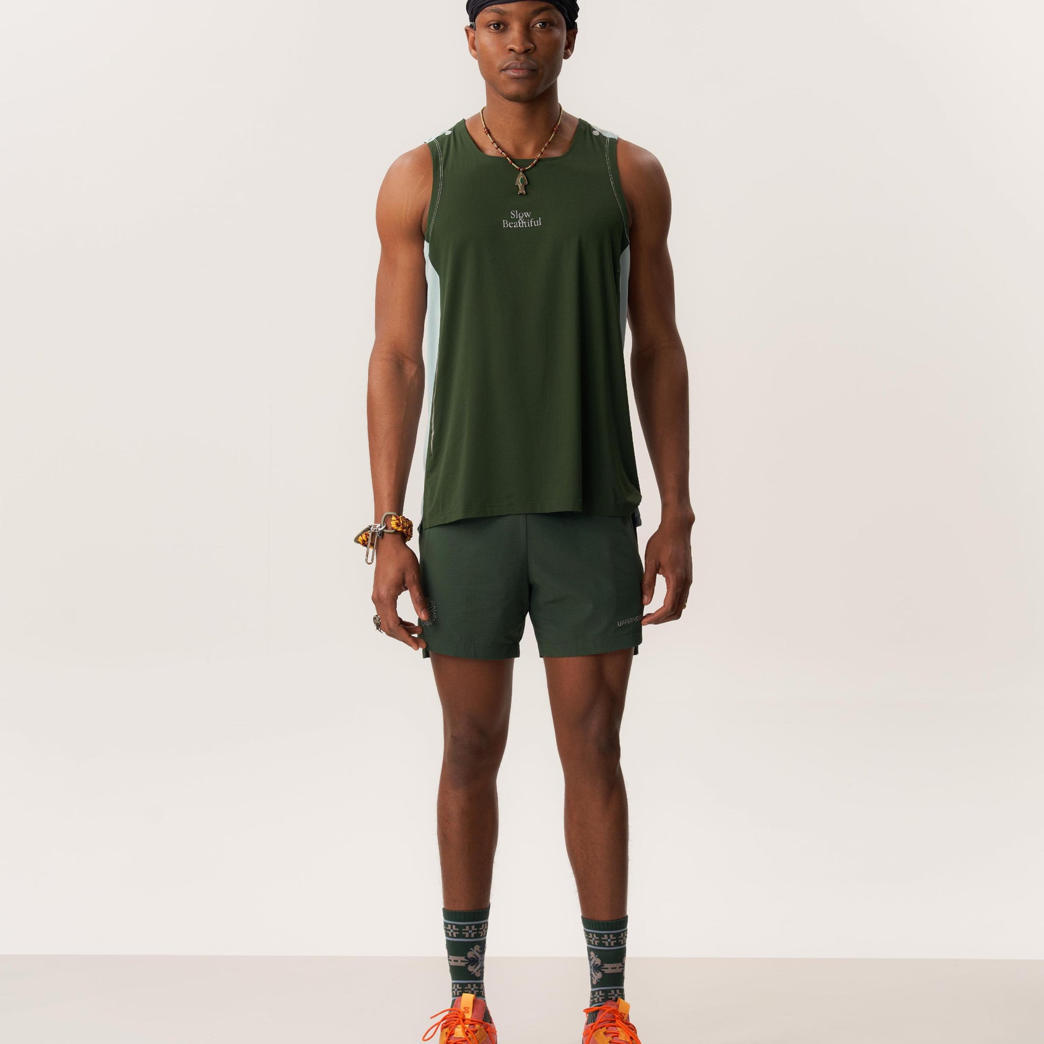 Model wearing breathable ERA CAP PRO Gore-Tex hat and green LAGO lightweight shorts designed for anti-chafing and outdoor activity