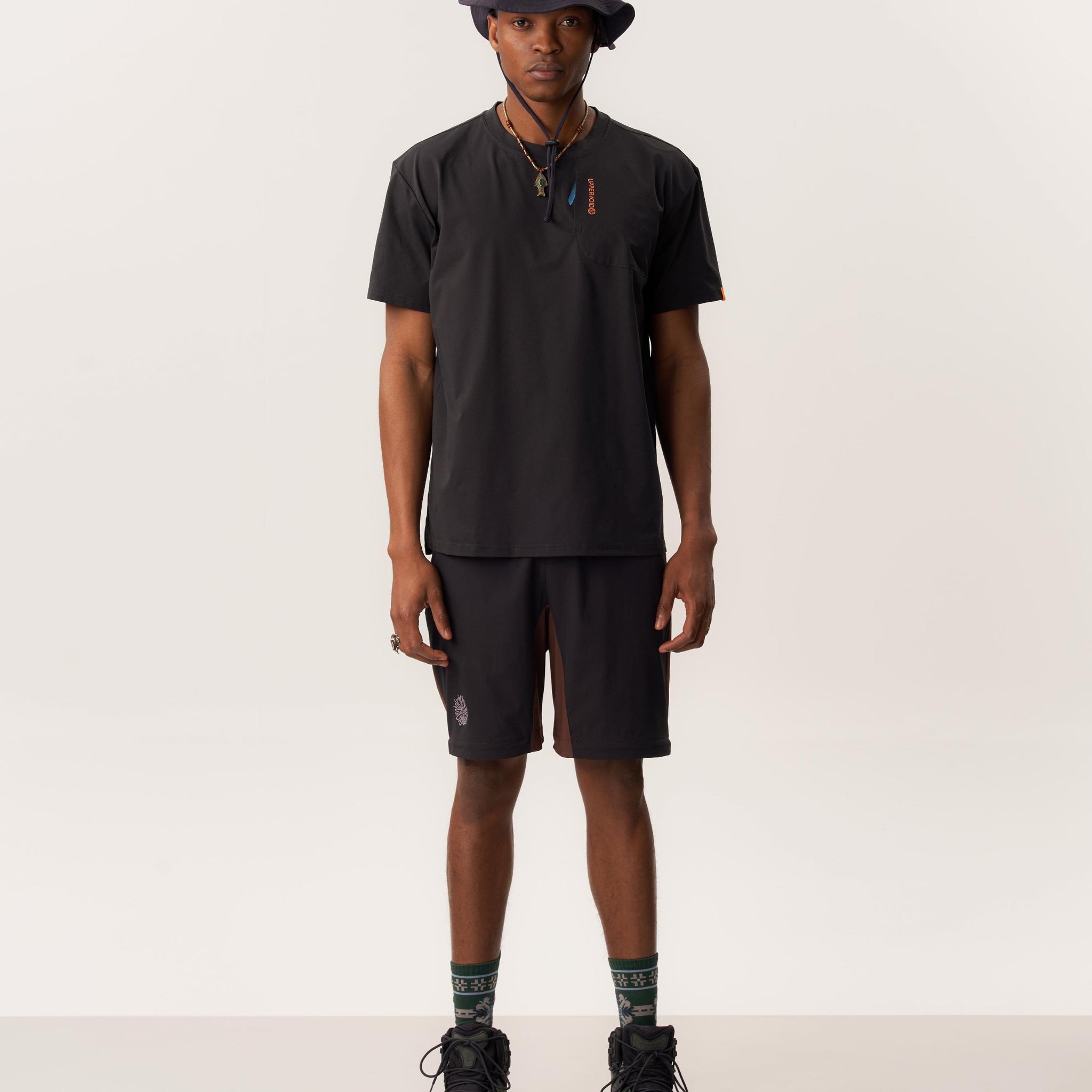 Model wearing moisture-wicking Ō TEE 2.0 Rare Bird printed t-shirt and lightweight STEFANO packable bucket hat in studio setting