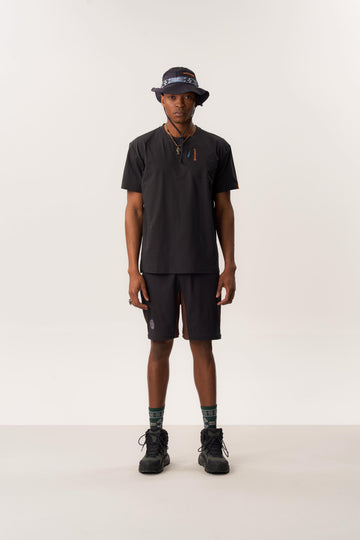 Model wearing moisture-wicking Ō TEE 2.0 Rare Bird printed t-shirt and lightweight STEFANO packable bucket hat in studio setting