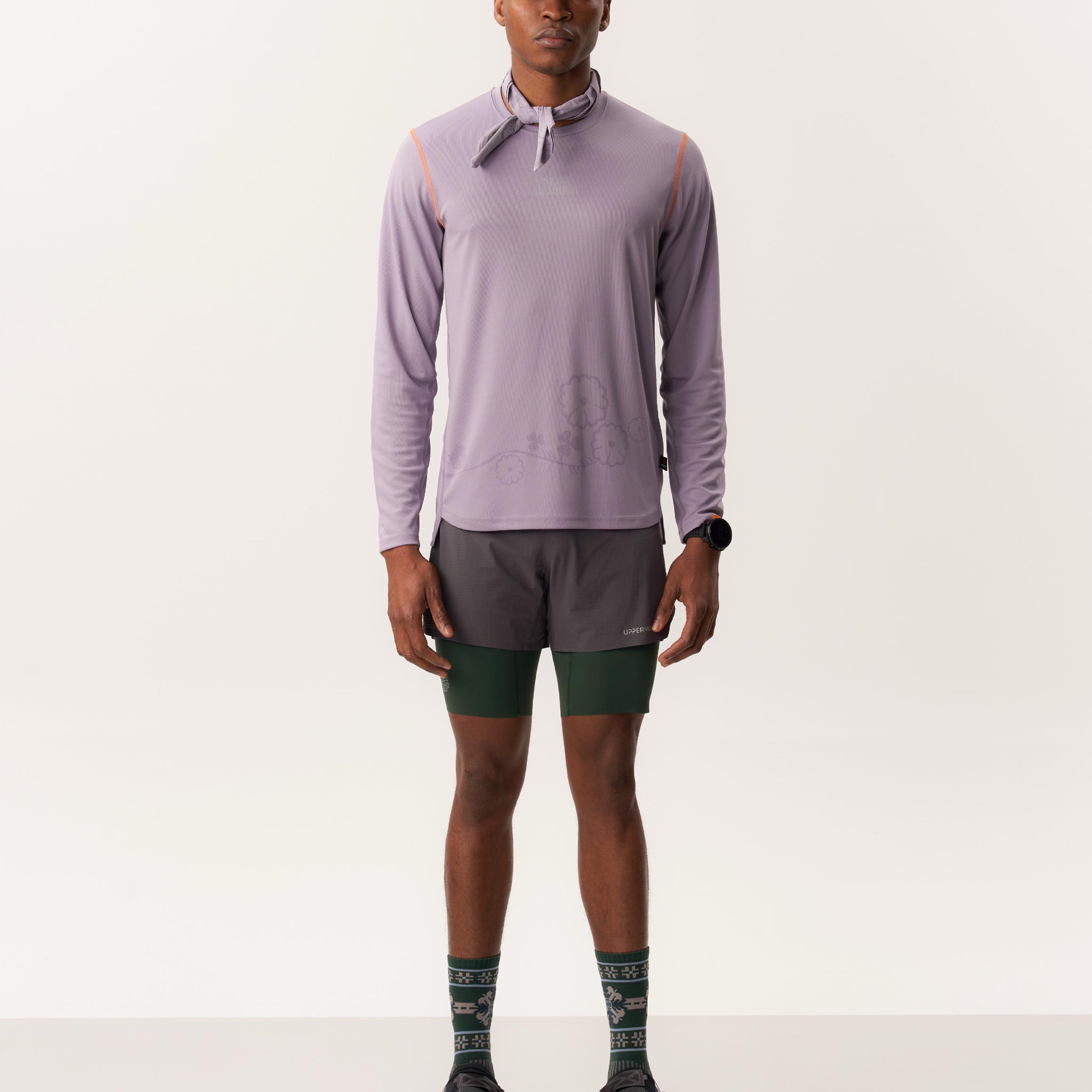 Model wearing a UPF Polartec Power Dry long sleeve shirt with quick-drying best trail running shorts in a studio setting