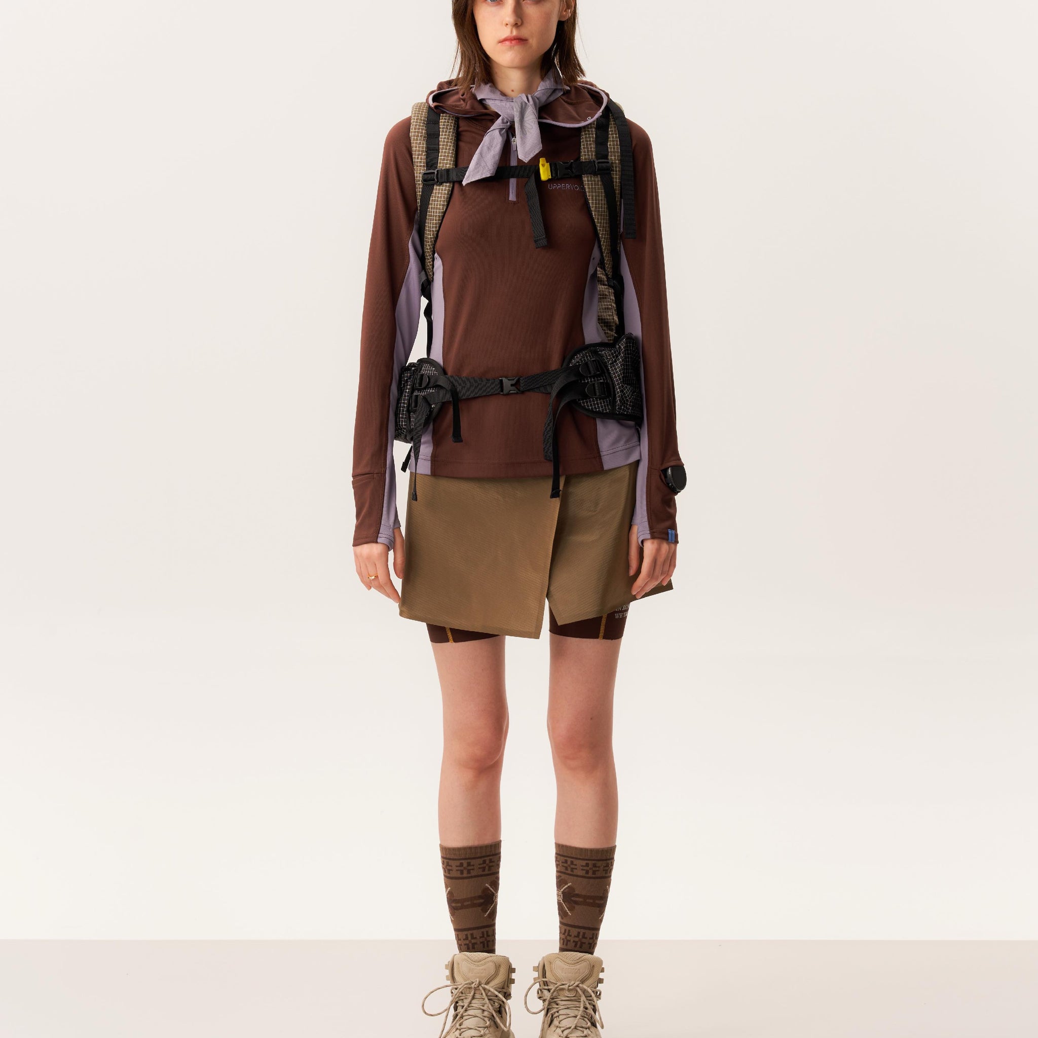 Model wearing moisture-wicking quarter zip pullover and waterproof hiking skirt with short silhouette in studio lighting