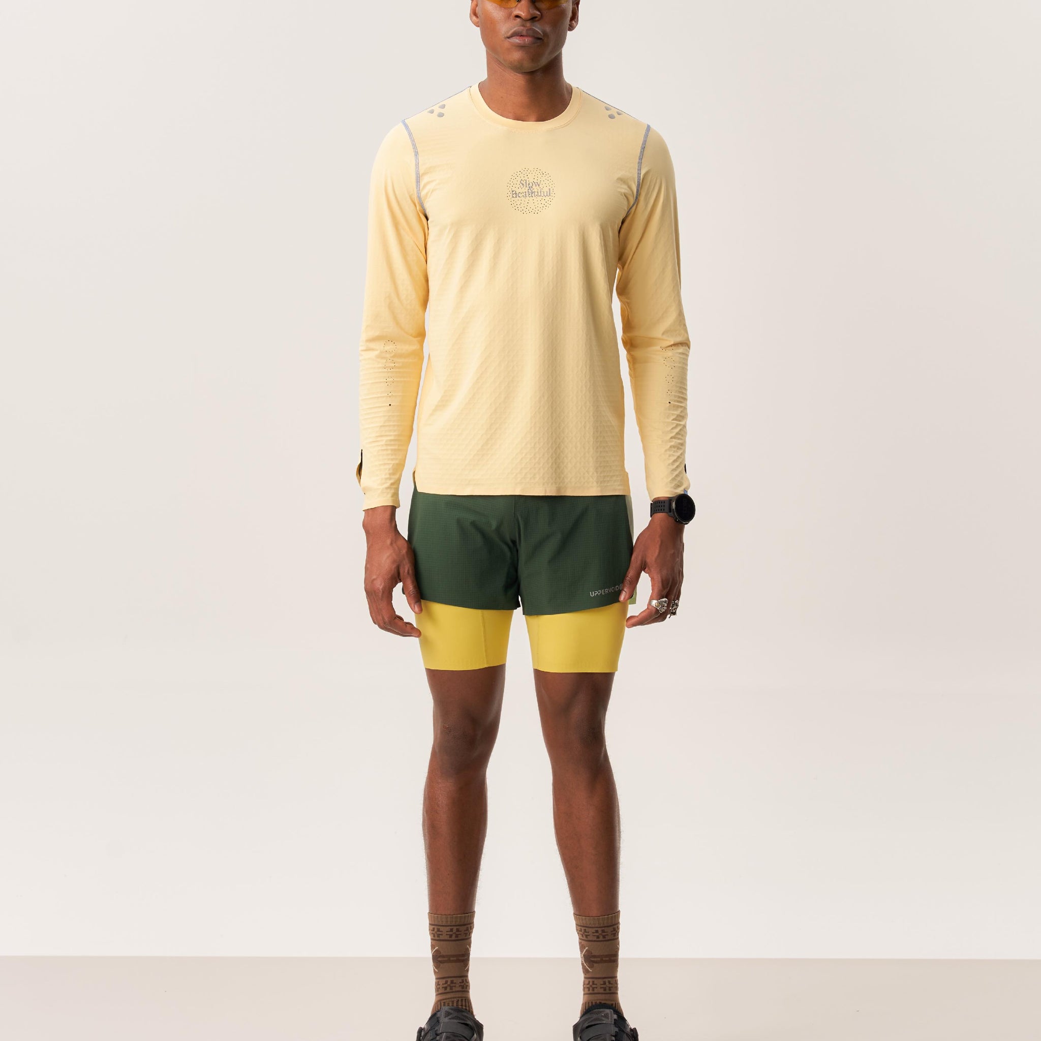 Model wearing TYET PRO moisture wicking long sleeve T-shirt and ENSIGN S lined running shorts in studio setup