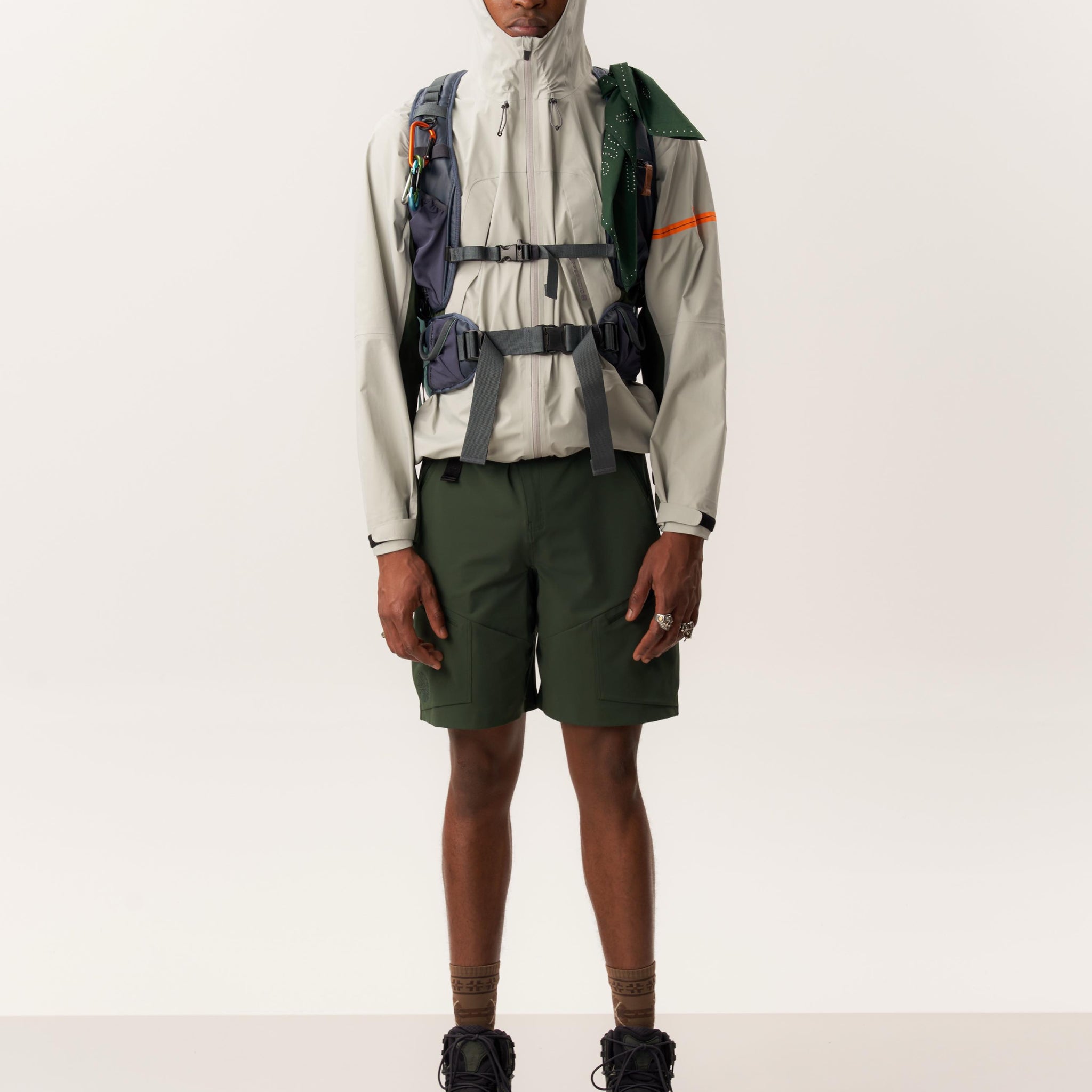 Model wearing ENIA waterproof windbreaker and ARUVAL quick-dry shorts in studio setup