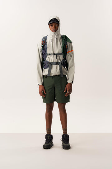 Model wearing ENIA waterproof windbreaker and ARUVAL quick-dry shorts in studio setup