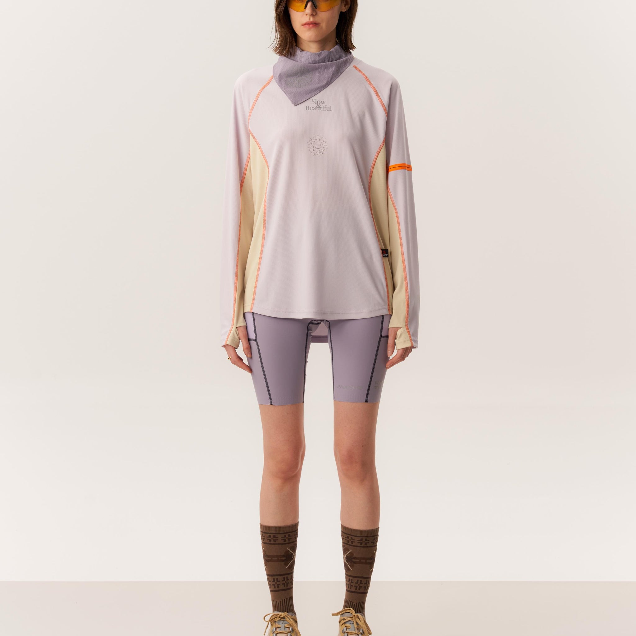 Model wearing SACI moisture-wicking long sleeve with OTHELLO seamless compression tights in studio setting