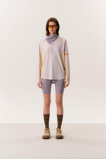 Model wearing SACI moisture-wicking long sleeve with OTHELLO seamless compression tights in studio setting